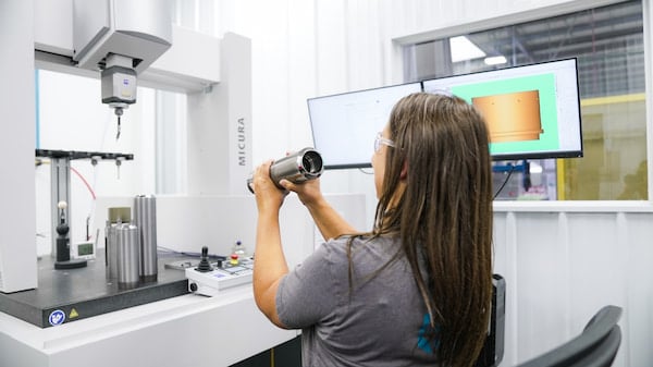 Quality inspection of a carbide precision can punch sleeve.